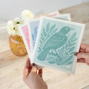 Hands holding the 100%NZ Swedish Dish Cloths in NZ Woodcut Birds design - reusable dish cloths with bird designs.