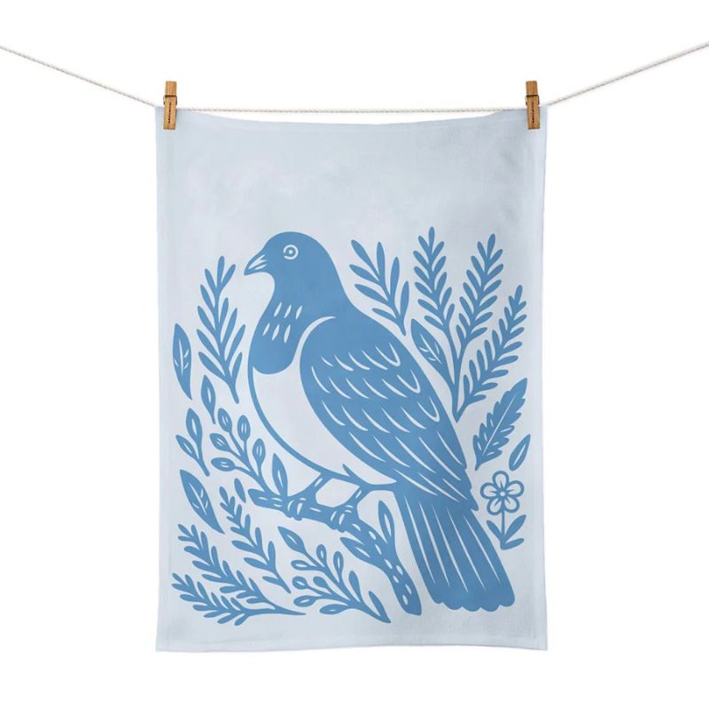 100%NZ Woodcut Kererū Tea Towel pegged to a line, shown against a white background.