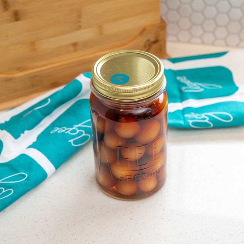 Agee tea towel with jar design styled beside jar of home preserves