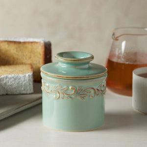 Antique Sea Spray Butter Bell Crock displayed on a white surface with cake slices and herbal tea in the background