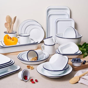 Set of white Bakemaster enamel dishes with blue rims on a neutral background