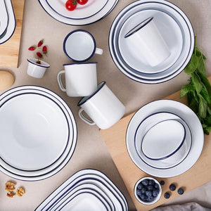 Bakemaster enamel dishes with blue rims on a wooden surface.