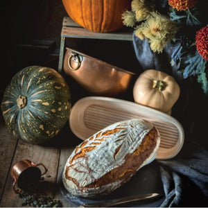Bakemaster oval proving basket displayed with a loaf of homemade artisan bread and pumpkins behind.