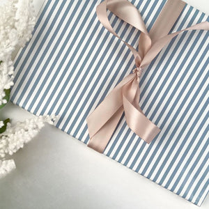 Striped smoky blue gift wrap with a vanilla coloured ribbon
