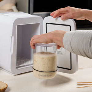 Person moving the Brod & Taylor Sourdough Starter Jar onto the Brod & Taylor sourdough home.