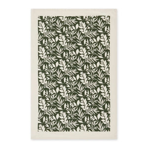 Close up view of tea towel with green foliage print on white cotton.