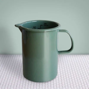 Dishy Enamel Measuring Jug in Tarragon shown front on against a green background.