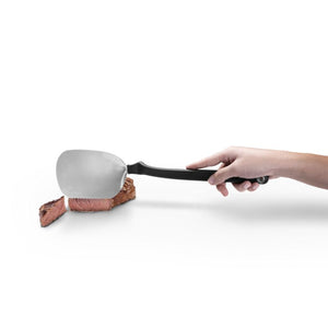 Hand holding the Dreamfarm BBQ Chopula slicing a beef steak.