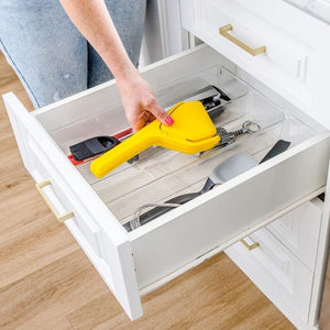 Woman placing Dreamfarm Fluicer Lemon Juicer in a drawer - Foldaway design shown | NZ