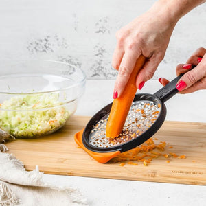 Woman using Dreamfarm Ograte Coarse Grater to grate carrot | NZ