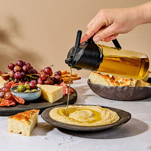 Dreamfarm Oileroo pouring oil into a bowl of hummus
