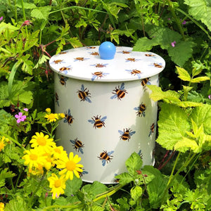 The Emma Bridgewater Blue Winged Bumblebee Biscuit Barrel in a garden setting