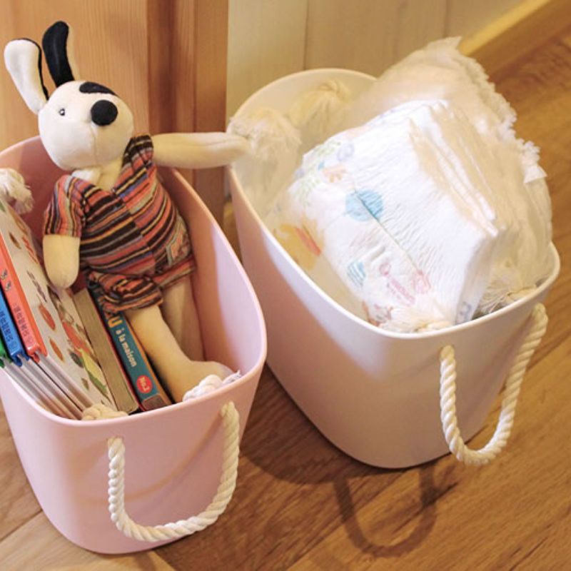 The 7L Hachiman Balcolore Storage Basket in white and pink being used to store nappies and other baby items