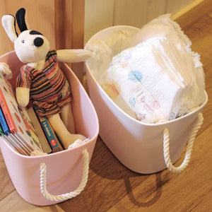 The 7L Hachiman Balcolore Storage Basket in white and pink being used to store nappies and other baby items