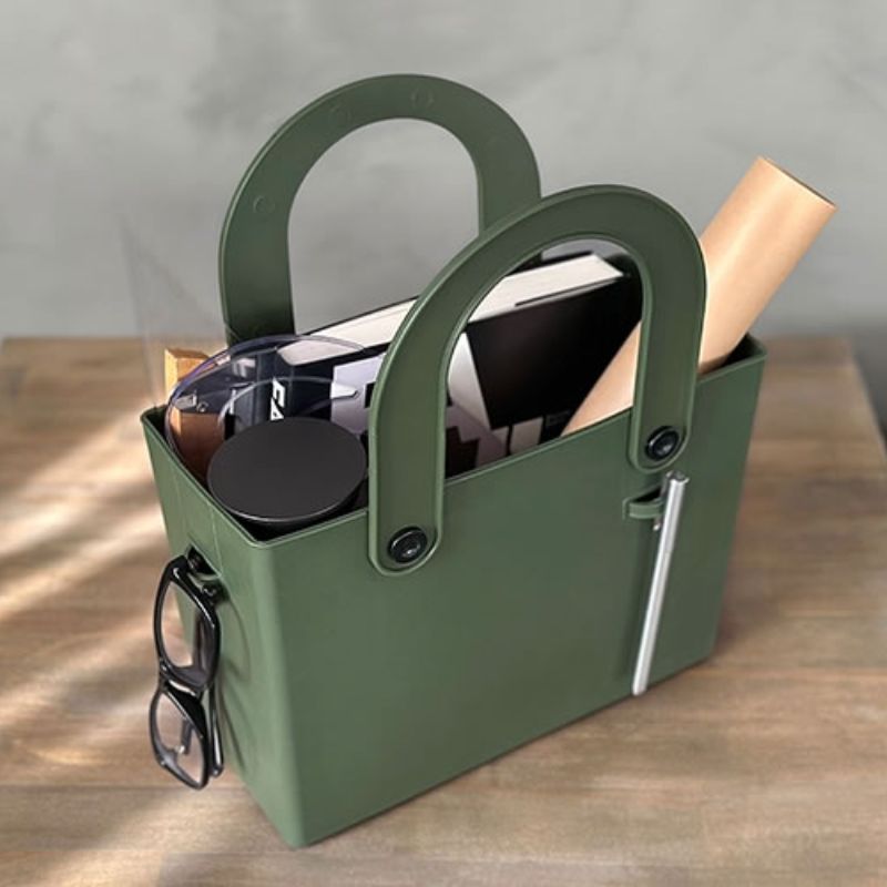 Hachiman Garden Tool Bag with Pocket on a bench filled with office items - loops on the sides of the bag being used to clip on glasses and a pen