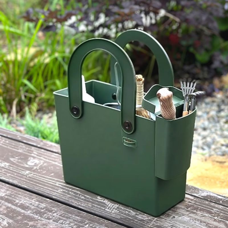 Hachiman Garden Tool Bag with Pocket in a garden setting shown with a variety of items in the main tote back and removable pocket