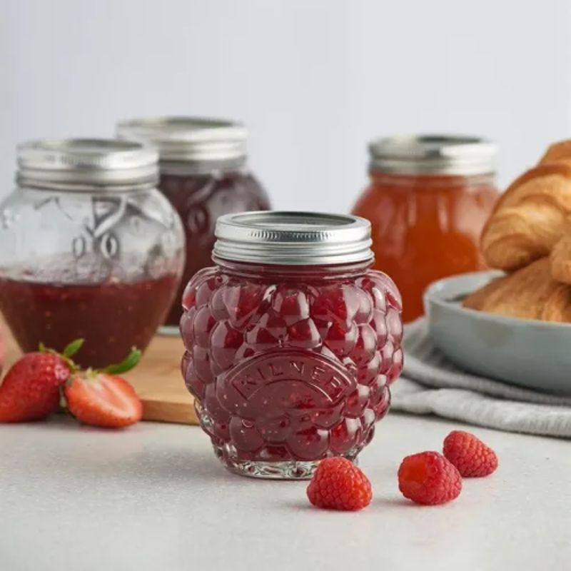 Kilner Fruit Preserve Jars filled with jams, surrounded by fresh berries and croissants - the Kilner Berry Fruit Preserve Jar in the foreground.