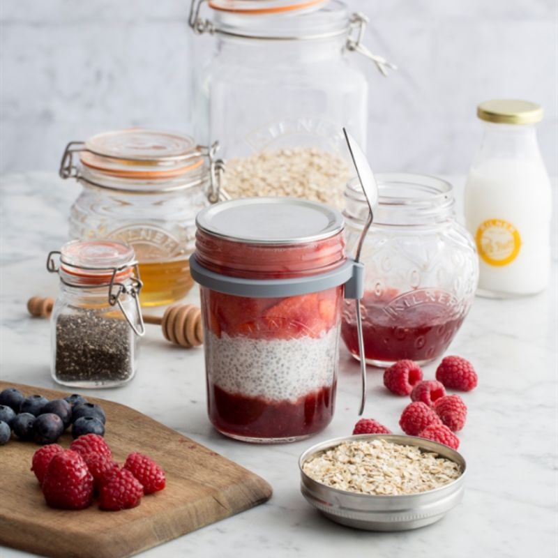Kilner Breakfast Jar filled with layers of oats, yoghurt, and fruit, shown with fresh berries and ingredients on a kitchen bench.