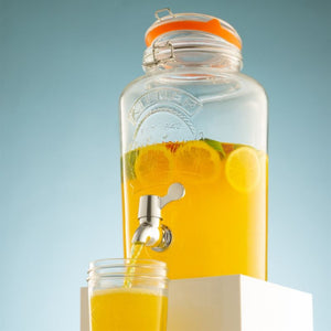 Kilner Round Clip Top Drinks Dispenser in 5L shown filled with orange juice with tap open and mason jar glass being filled.