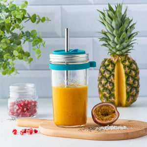 Kilner Smoothie Making Set shown filled with a smoothie, and pineapple, passionfruit and pomegranate seeds nearby in a kitchen scene.