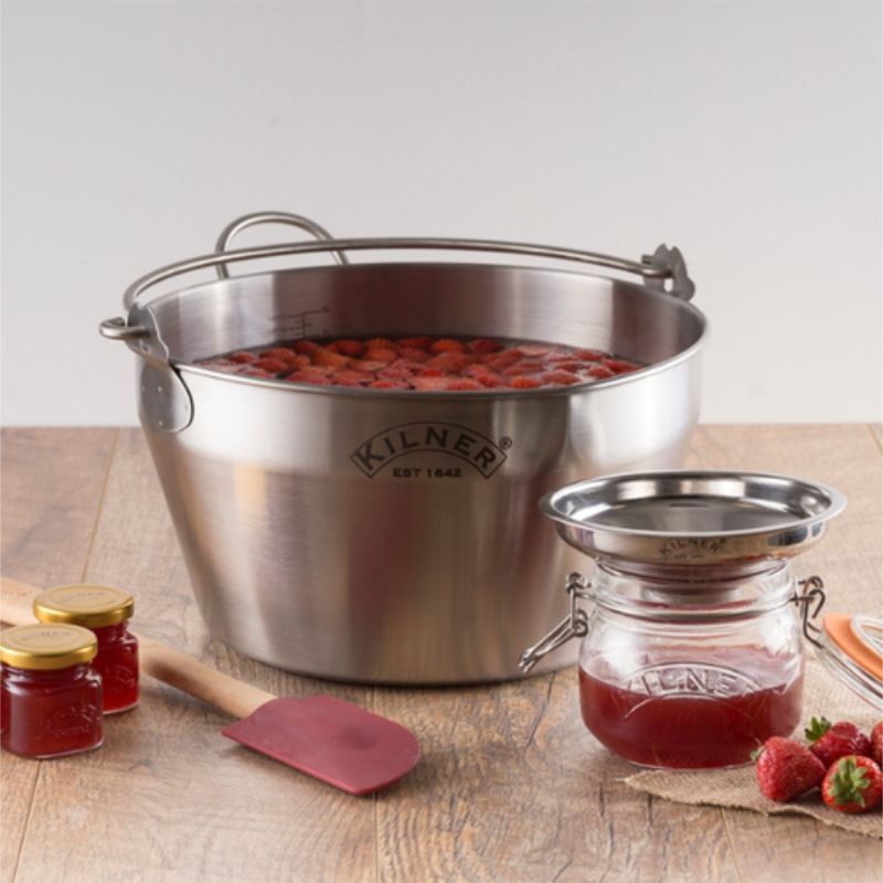 Kilner jam-making equipment with strawberries and jars on a wooden surface - Kilner Stainless Steel Preserving Pan, jar funnel and jars shown.