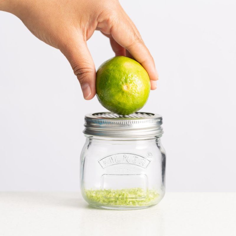 Hand zesting a lime over Kilner Storage Jar with Fine Grater