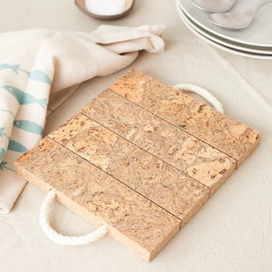 Liga cork block trivet with natural cork grain pattern and rope handle.
