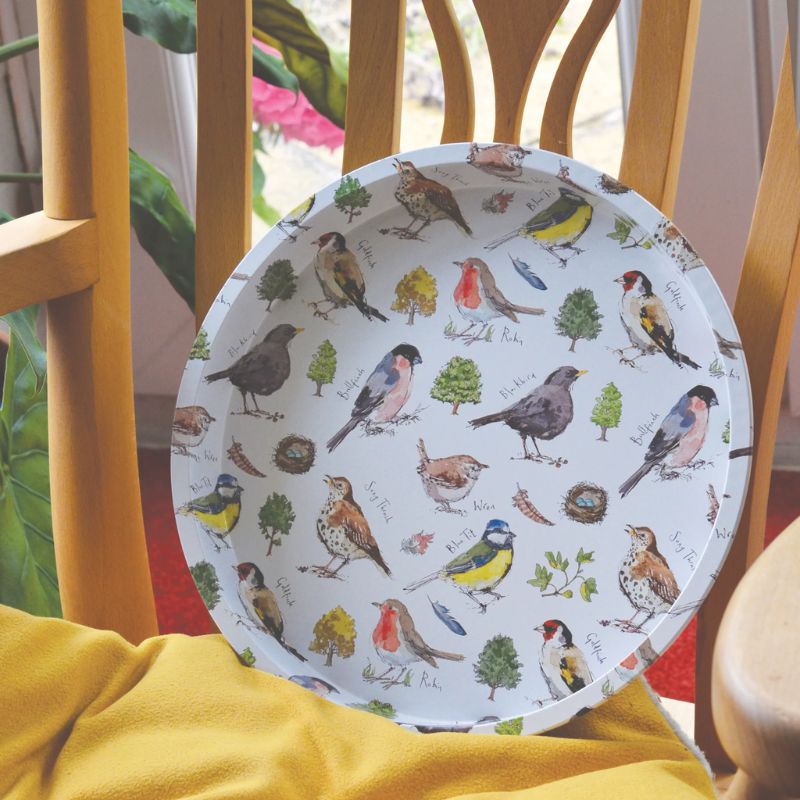 The Madeleine Floyd Bird Song Tin Tray propped up on a wooden chair