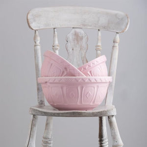 Mason Cash Powder Pink Colour Mixing Bowls styled on a chair against a grey background.