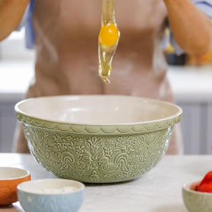 Mason Cash Home To Roost Hen Mixing Bowl in Green (29cm), shown with an egg being cracked into it.