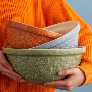 Mason Cash Home To Roost Hen Mixing Bowls stacked together against an orange background.