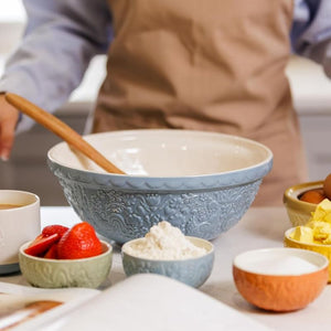 Person using the Mason Cash Home To Roost Prep Bowls to hold various ingredients on a table.