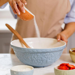 Person pouring sugar into a large blue bowl using the Mason Cash Home To Roost Prep Bowls.