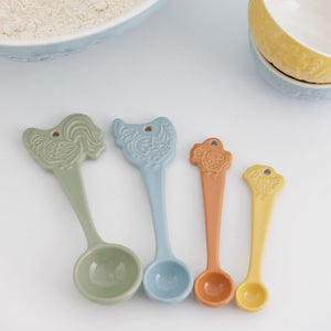 Four Mason Cash Home to Roost measuring spoons arranged beside mixing bowls
