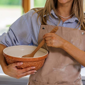 Mason Cash Home To Roost Hen Mixing Bowl in Orange (24cm) being held under the arm.