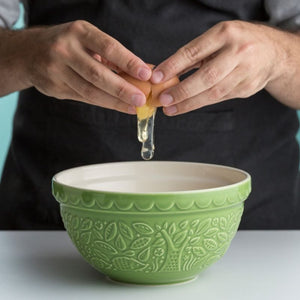 Person cracking an egg the Mason Cash In The Forest Green Hedgehog Mixing Bowl