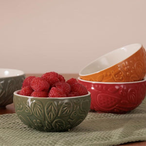 Set of four Mason Cash In The Forest Prep Bowls with raspberries on a textured surface