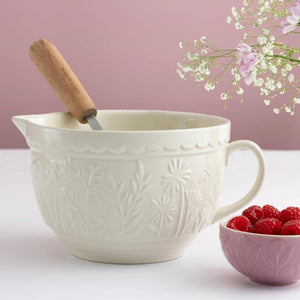 Mason Cash cream batter bowl on a table with raspberries and flowers