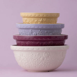 Stack of Mason Cash In the Meadow mixing bowls in multiple colours, including cream, berry, lilac, and yellow