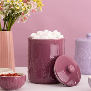 Mason Cash In The Meadow Storage Jar in purple filled with sugar cubes on a light pink background.