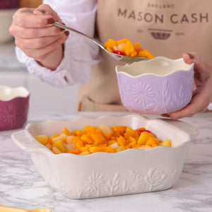 Person serving fruit into the Mason Cash In The Meadow Square Oven Dish