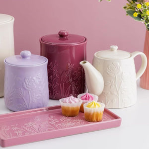 Mason Cash In The Meadow Storage Jar, teapot, and pink tray with cupcakes on a pink background
