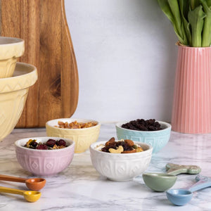 Mason Cash Pastel Prep Bowls (Set of 4) styled next to a wooden chopping board and matching measuring spoons, on a marble surface.