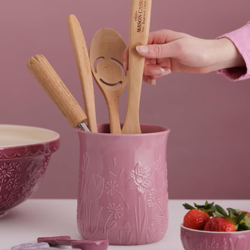 Pink Mason Cash In The Meadow utensil pot with hand placing wooden spoons inside