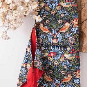 Close up of the Museums & Galleries Strawberry Thief apron with dried flowers nearby.