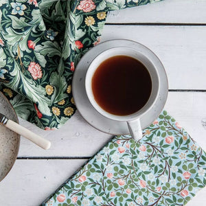 V&A Dearle Designs tea towel beside a cup of tea.