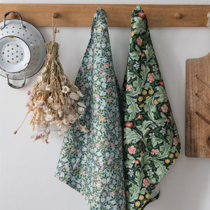 V&A Dearle Designs floral tea towels hanging beside wooden chopping boards and dried flowers.