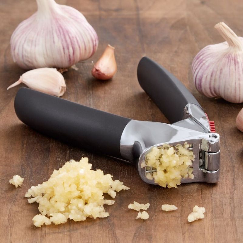 OXO Good Grips Garlic Press with black handles and a silver head on a white background