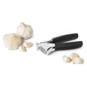 OXO Good Grips Garlic Press with garlic cloves on a white background