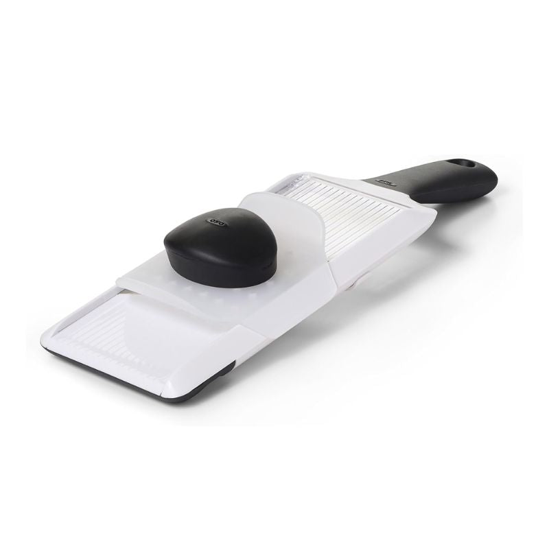 White OXO Good Grips Hand Held Mandoline Slicer with black handle and safety guard displayed on a white background.